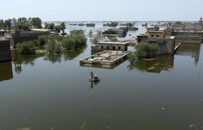 Des personnes utilisent un radeau de fortune pour naviguer dans les eaux de crue dues aux pluies de mousson, dans le district de Dadu de la province de Sindh au Pakistan, le 9 septembre 2022. (AP Photo AP / Fareed Khan)